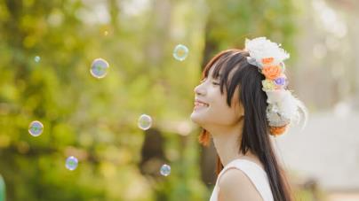 girl smiling with eyes closed and bubbles in the air